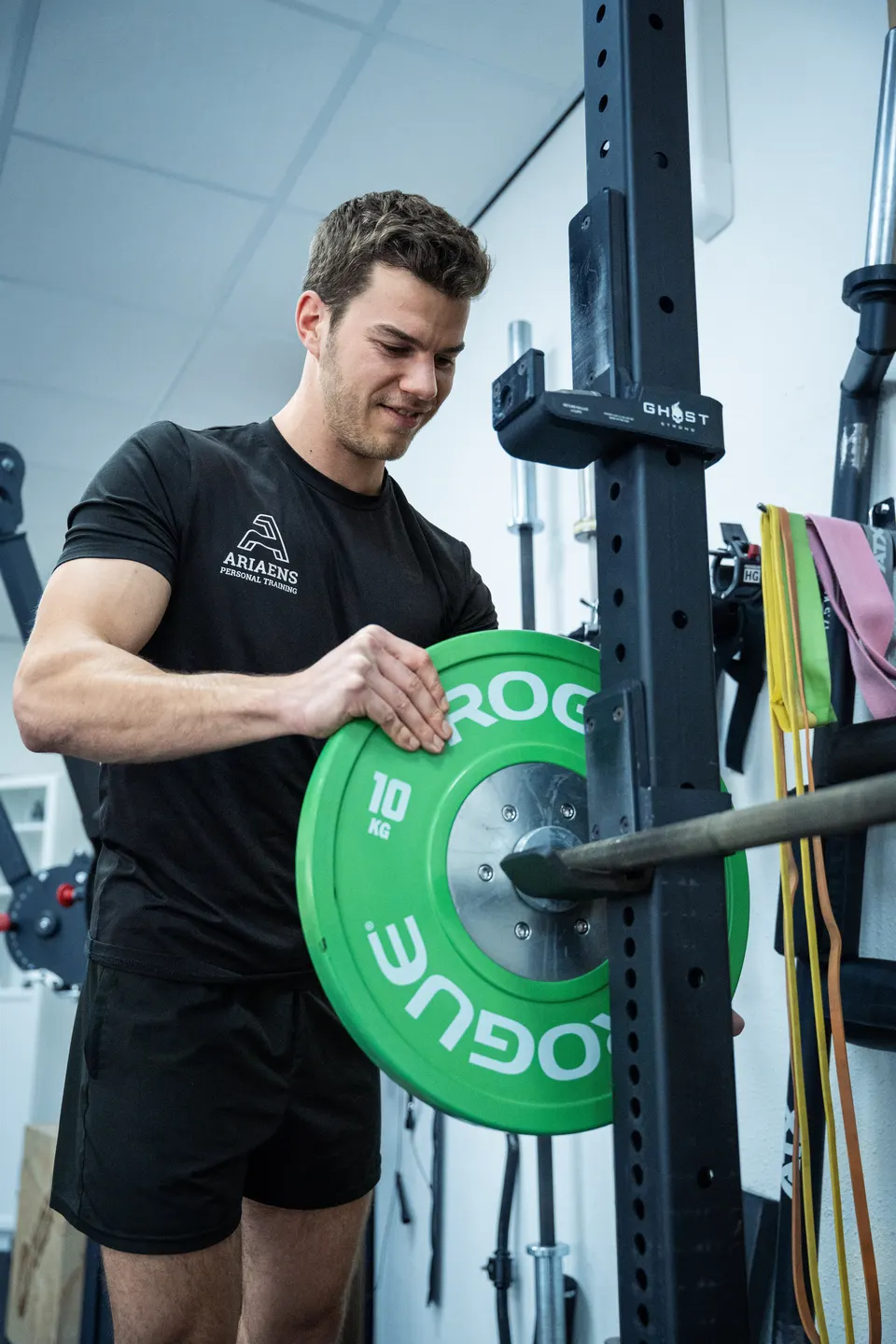 Arieans Personal Training coach changing a weight plate