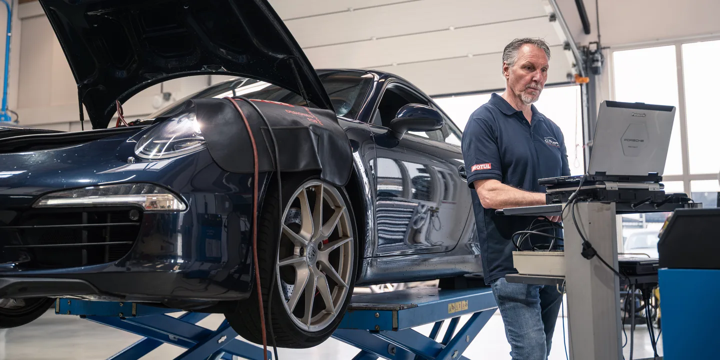 Technician beside a car on a lift