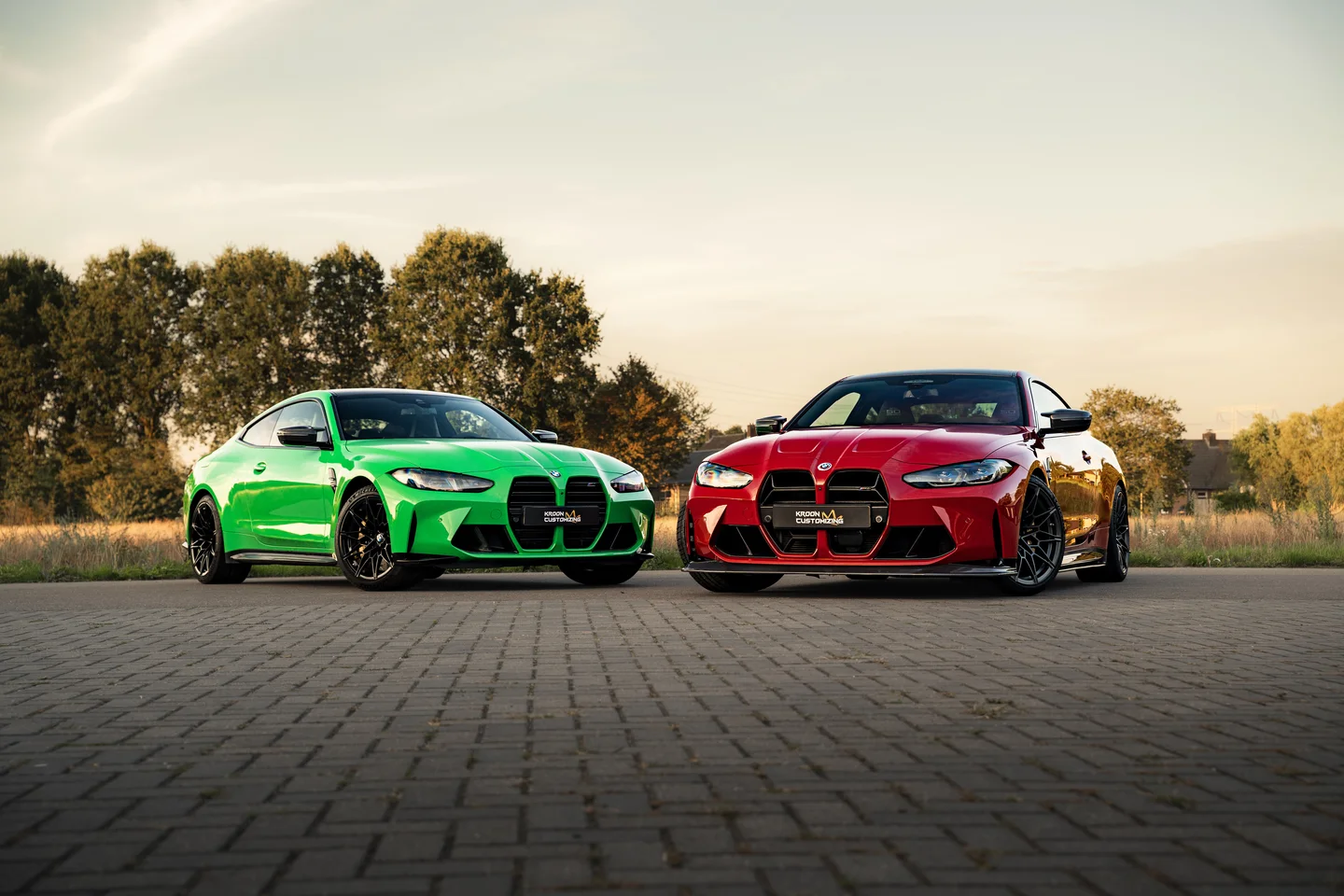 Green and red BMW together in warm evening light