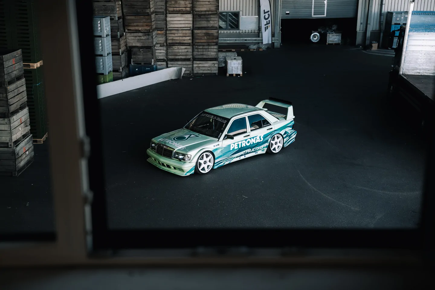 Petronas-liveried Mercedes in front of stacked wooden crates