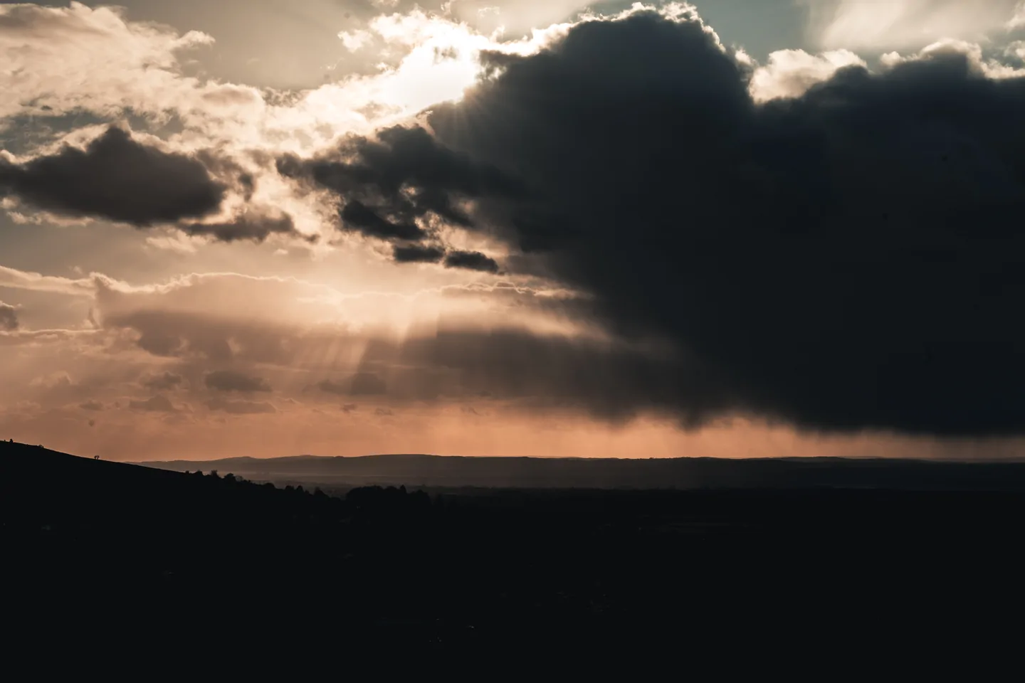 Sun rays over a rolling landscape