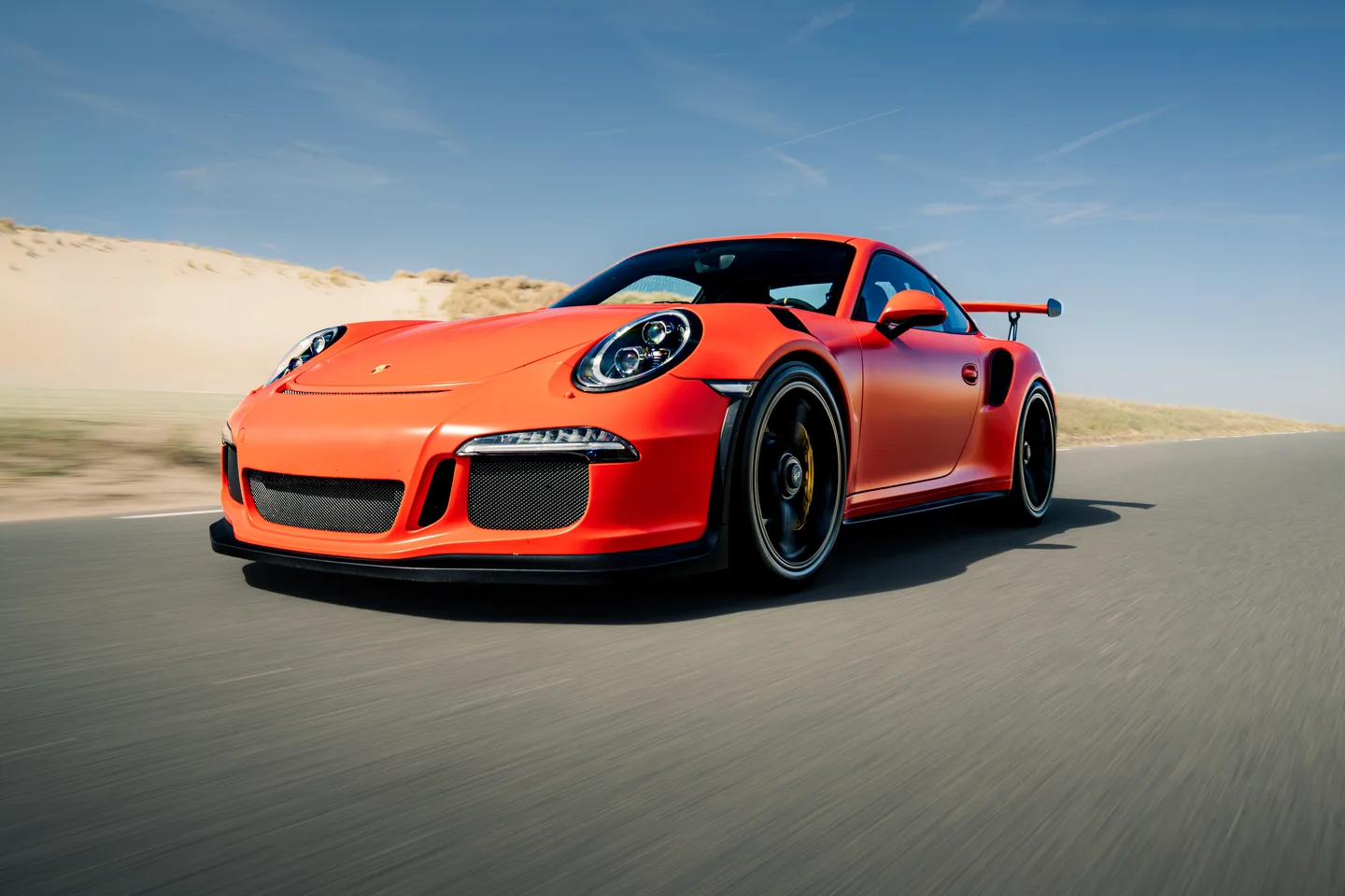 Red Porsche GT3 RS photographed in motion on the road