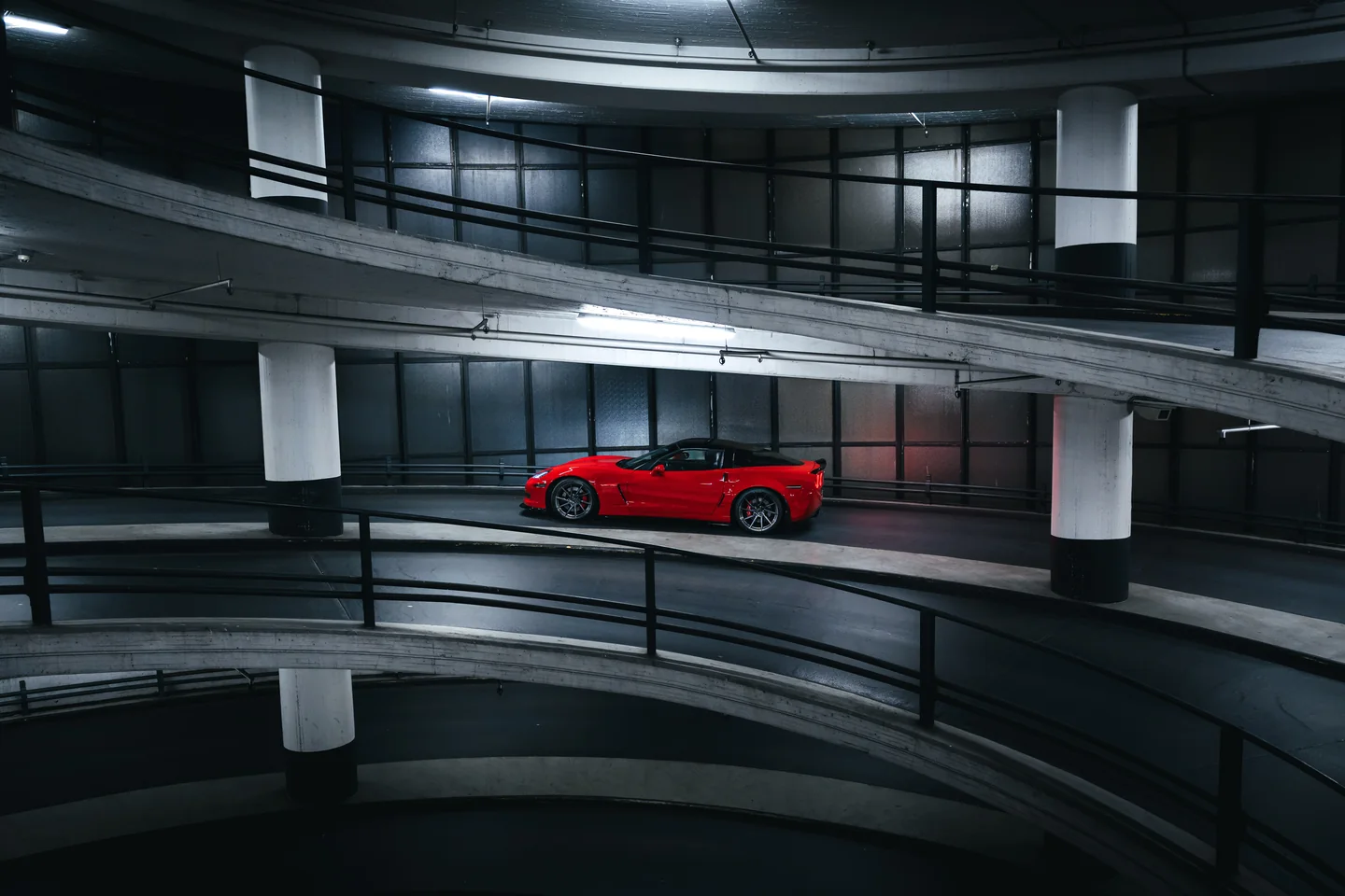 Red Corvette inside a circular parking garage