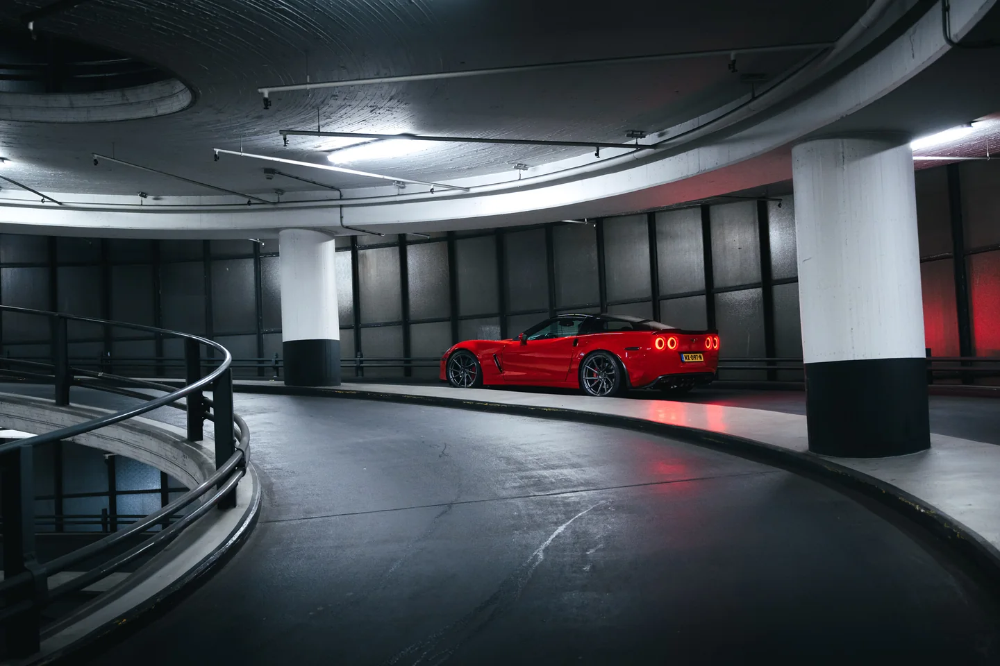 Red Corvette beneath graphic artificial light
