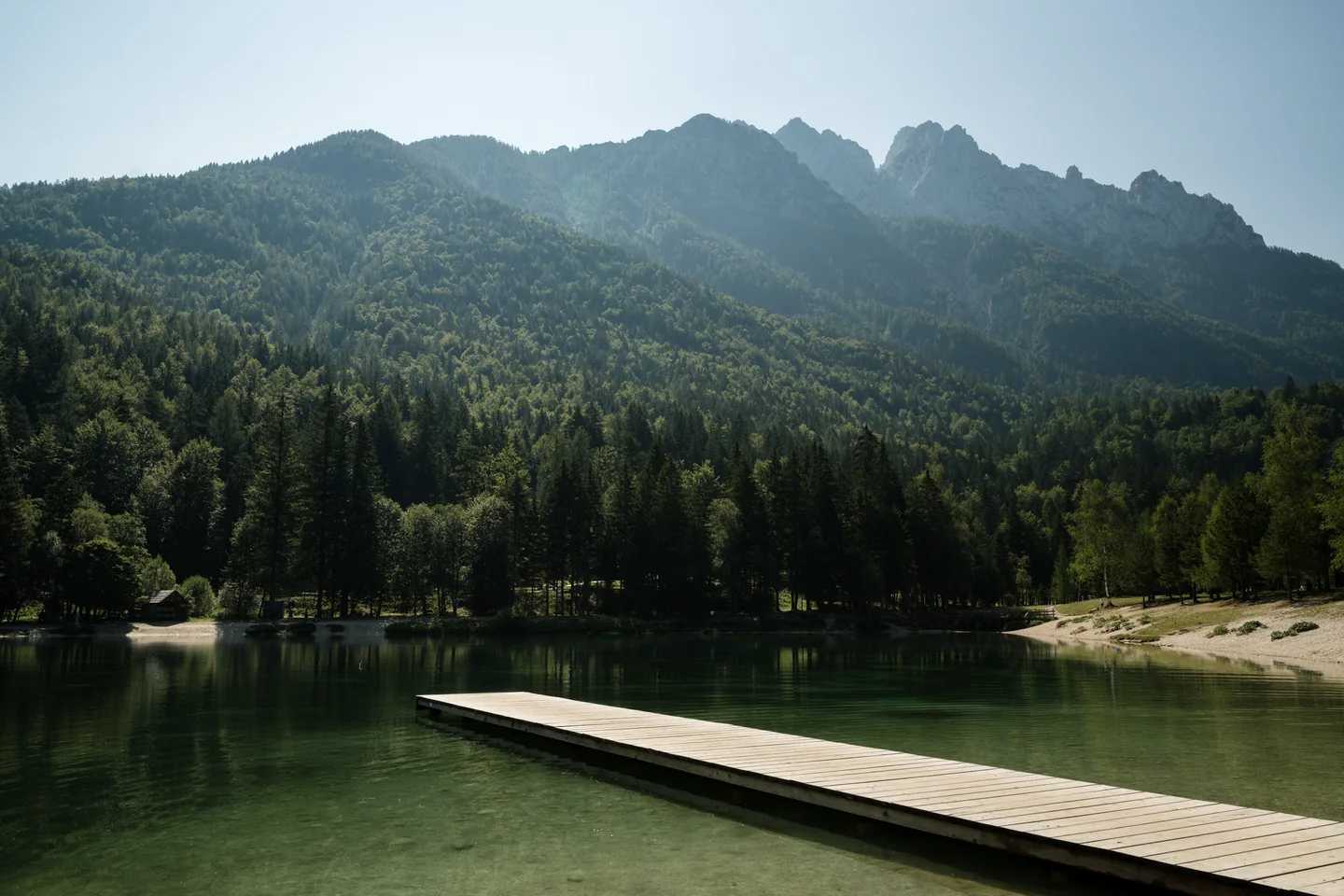Mountain lake with a jetty and wooded slopes