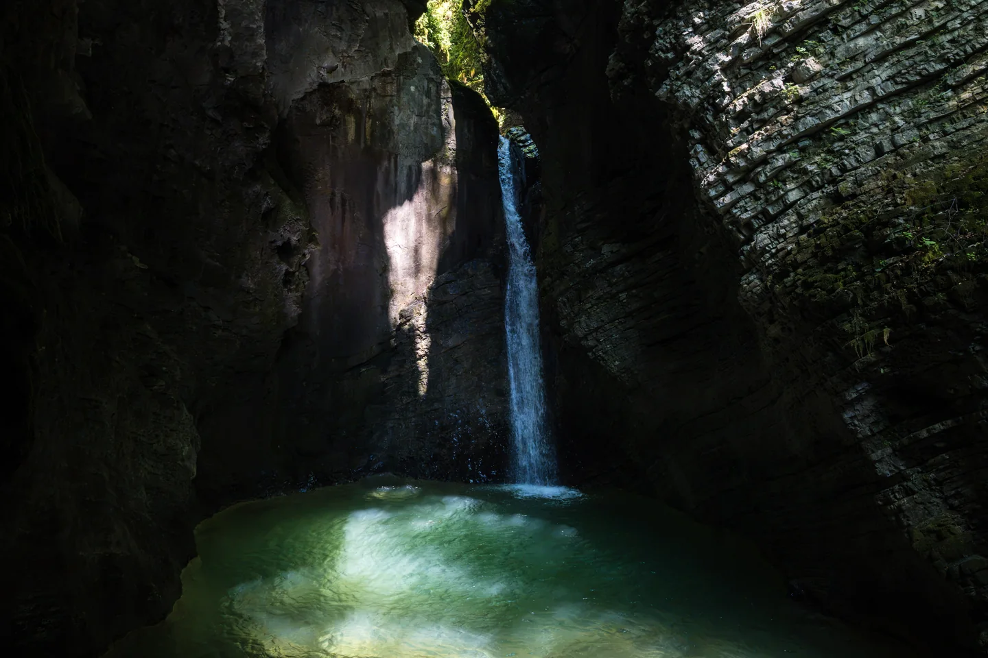 Waterfall inside a dark rocky basin
