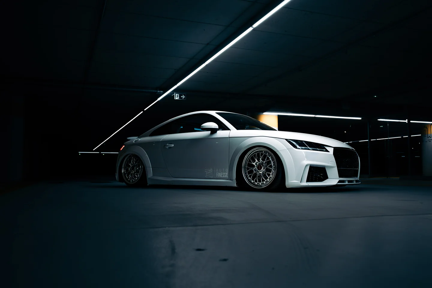 White Audi TT in profile beneath strip lighting